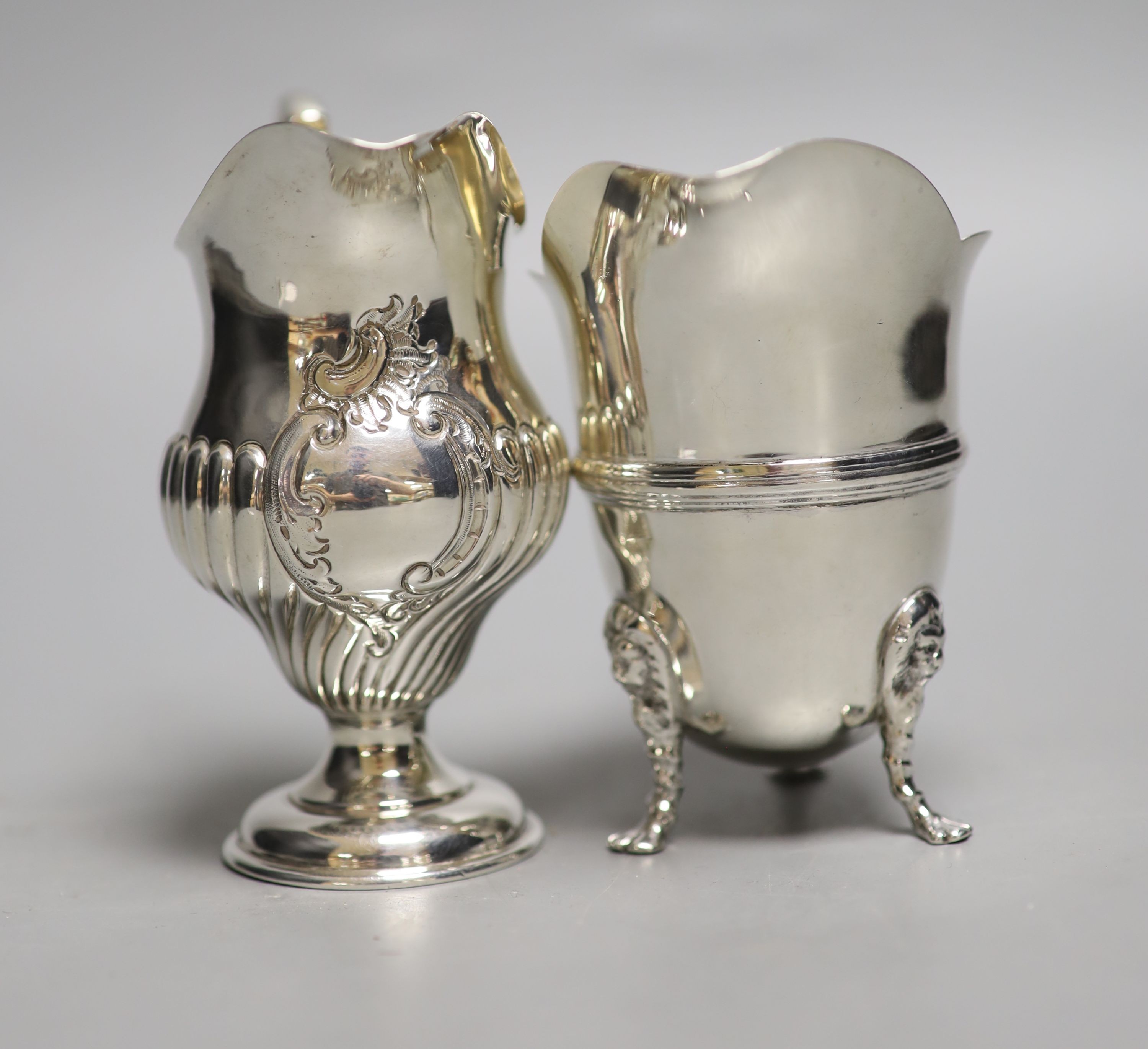 A late Victorian silver inverted pear shaped cream jug, Birmingham, 1894, 10.6cm, and a later silver cream jug, 8oz.